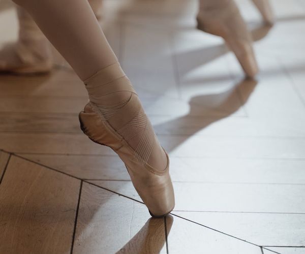 Detailed shot of athletic shoes and a clean studio floor.